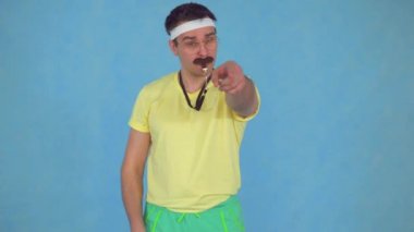 80'li bir bıyık ile bir ıslık ile Komik adam koç, mavi bir arka plan üzerinde
