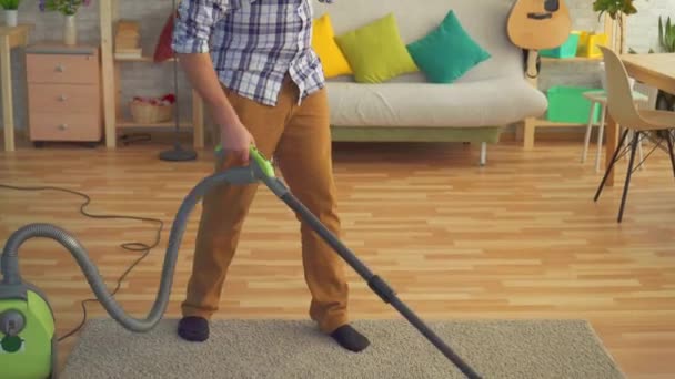 Young man disabled person without a hand cleans the house with a vacuum cleaner and looks at the camera — 비디오