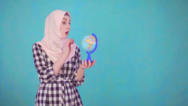 Young beautiful Muslim woman with globe model looking at camera smiling — Stock Video