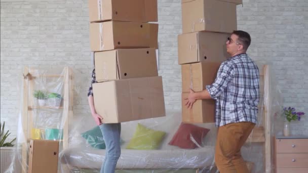 Супружеская пара с коробками в руках неуклюже падает медленно — стоковое видео