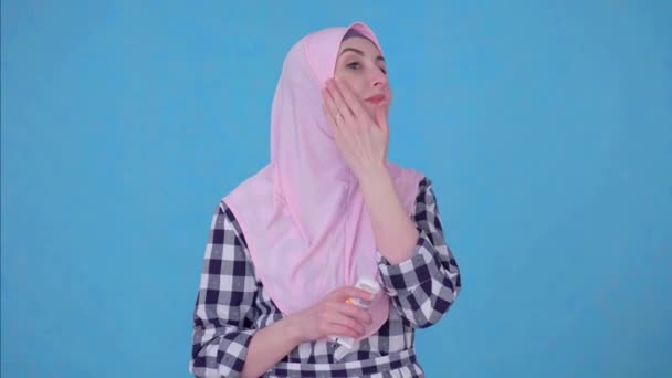 Portrait young Muslim woman uses face cream — Stock Video