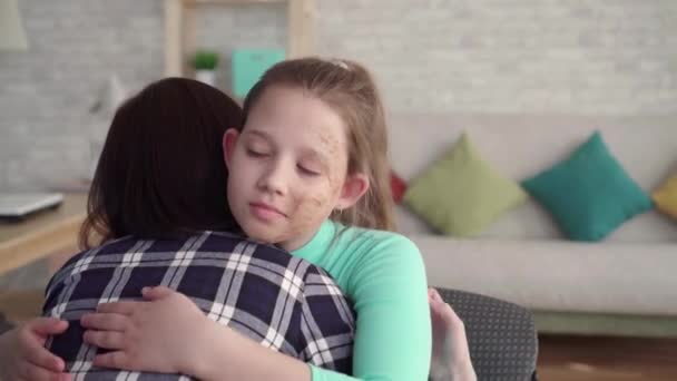 Dramatic shot of a girl with a facial defect embracing her mother — Stock Video