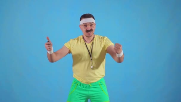 Grappige vrolijke mannelijke trainer uit de jaren 80 met een snor en een bril met een stopwatch slow mo — Stockvideo