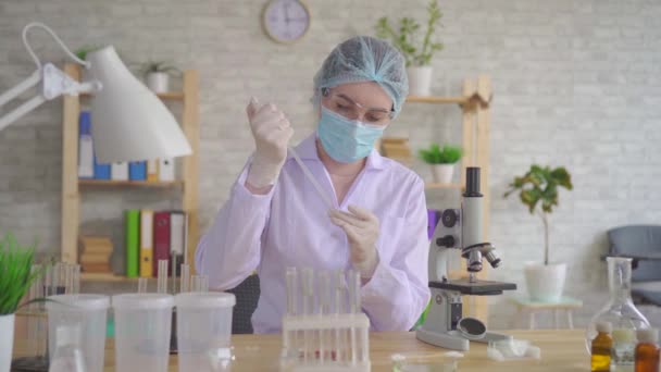 Técnico de laboratorio mujer de cerca lleva a cabo la investigación con un microscopio — Vídeo de stock