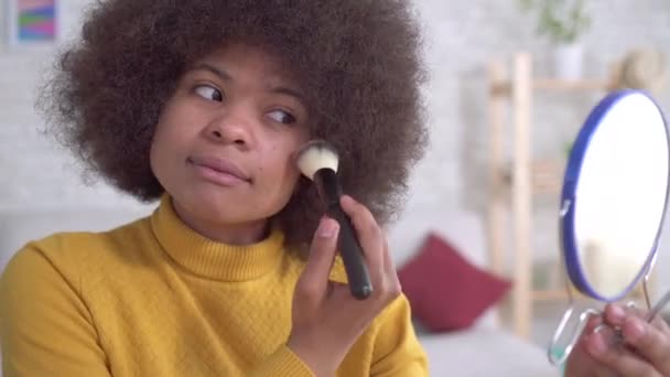 Retrato mujer afroamericana maquillaje positivo mirando en el espejo en apartamento moderno — Vídeo de stock