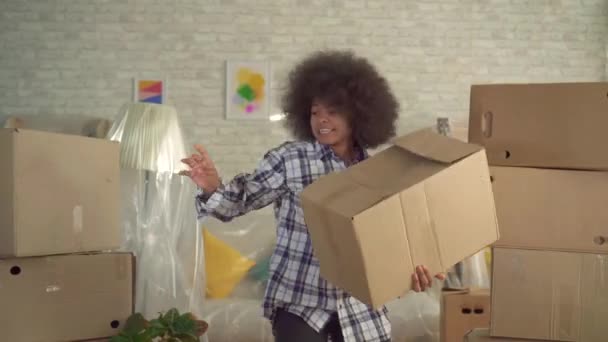 Afrikaanse vrouw met een Afro kapsel expressieve dansen met een doos in zijn hand — Stockvideo