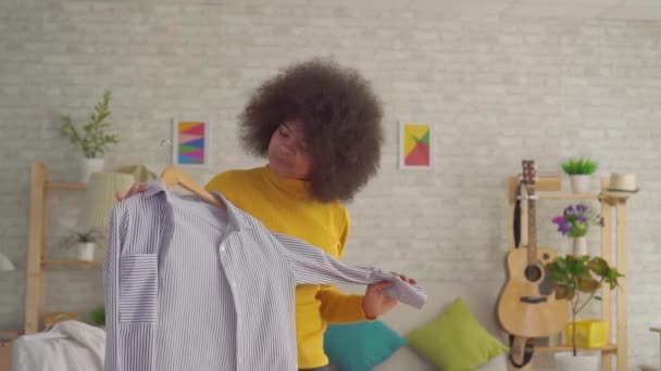 非洲妇女与一个fro发型尝试在他的现代公寓镜子前的衣服慢莫 — 图库视频影像