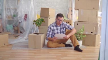 portre yorgun ve üzgün orta yaşlı adam kutuları arasında gözlük ile taşımak için, tahliye için belgeleri okur