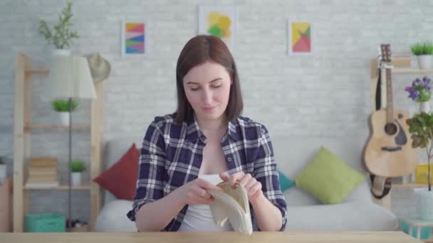 Шокированная молодая женщина заглянула в сумочку, концепцию, идею отсутствия денег — стоковое видео