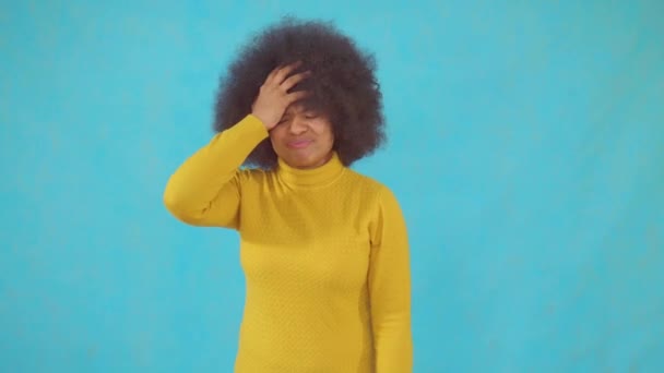 Face palma mulher africana com um penteado afro em uma jaqueta amarela — Vídeo de Stock