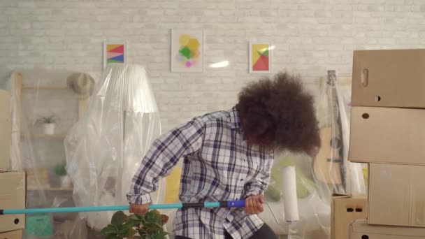 Happy african american woman dancing with paint roller like guitar player slow mo — Stock Video