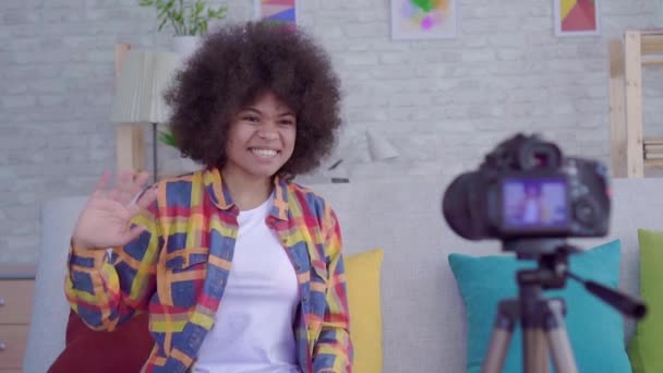 Ung afroamerikansk kvinna med afro frisyr bloggare skriver video i vardagsrummet slow mo — Stockvideo