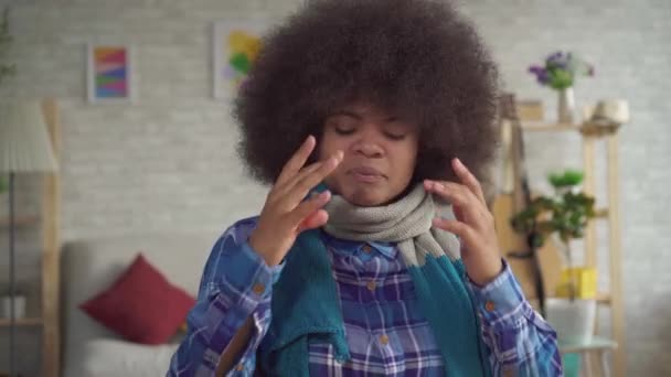 Cansada mujer joven afroamericana con peinado afro con bufanda en el cuello está enfermo, utiliza spray nasal — Vídeo de stock
