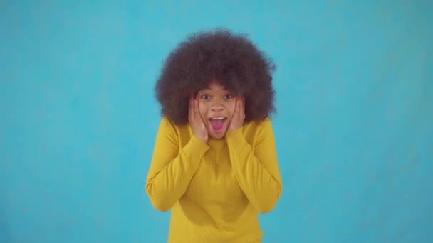 Joyful känslomässig afrikansk kvinna med en afro frisyr i en gul jacka — Stockvideo