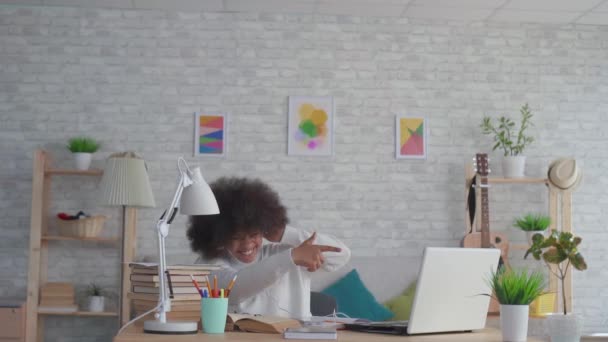 African american woman with an afro hairstyle listening to music with headphones and dancing slow mo — Stock Video