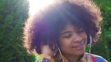 Gömlek ve kulaklıklar afro saç modeli ile mutlu Afrikalı Amerikan kadının portresi