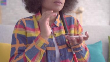 bir afro saç modeli ile kör afrikalı kadın yakın akıllı telefonunuzda ses asistanı kullanır