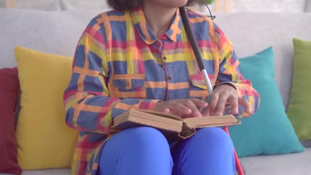 Κλείστε τυφλή αφρικανική Αμερικανίδα γυναίκα με ένα Άφρο χτένισμα διαβάζοντας ένα βιβλίο με τα δάχτυλά σας — Αρχείο Βίντεο