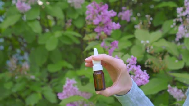 Nässpray allergi användning på bakgrunden av blommande växter — Stockvideo