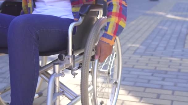 Mãos de uma mulher africana deficiente em uma cadeira de rodas na rua close-up — Vídeo de Stock