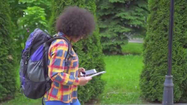 Porträtt afrikansk kvinna turist med en afro frisyr med telefon i handen — Stockvideo