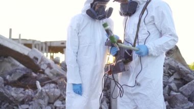 koruyucu giysiler ve maskeler iki bilim adamı ve gün batımında kalıntıların arka plan karşı kişisel iyonlaştırıcı radyasyon dosimetre ölçümleri yapmak