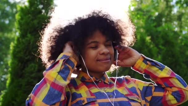 Portret van Happy African American vrouw met Afro kapsel in shirt en hoofdtelefoon slow mo — Stockvideo