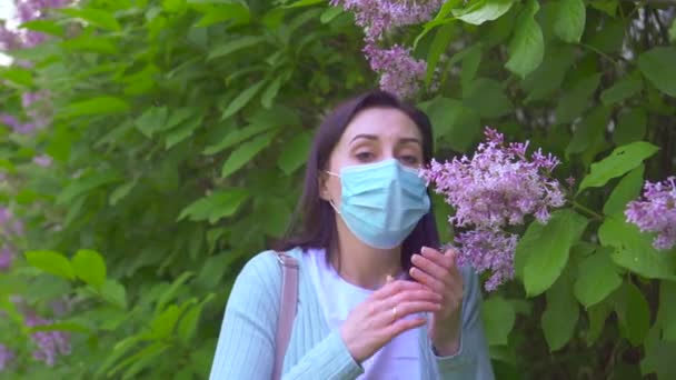 Portret młodej kobiety alergicznej w Sneezes maska medyczna i patrzy na aparat fotograficzny — Wideo stockowe