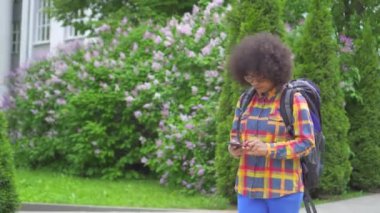 Elinde telefon ile bir afro saç modeli ile Portre şaşkın ve şaşkın Afrikalı kadın turist