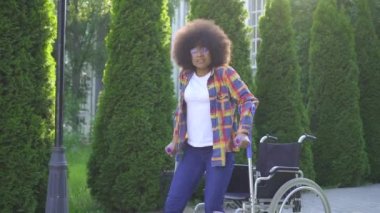 afro saç modeli ile Afrikalı kadın bir yaralanma sonra tekerlekli sandalyeden kalkar