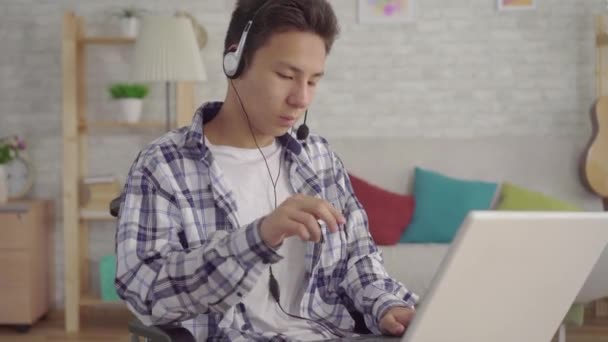 Konzept der Fernarbeit, junge asiatische Mann Arbeiter in Kopfhörer sprechen Anruf Beratung Client — Stockvideo