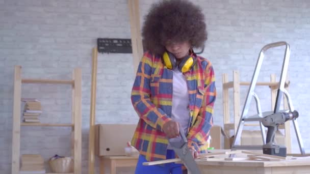 Afroamerikanerin mit Afrofrisur verletzt sich bei Arbeit in der Werkstatt — Stockvideo