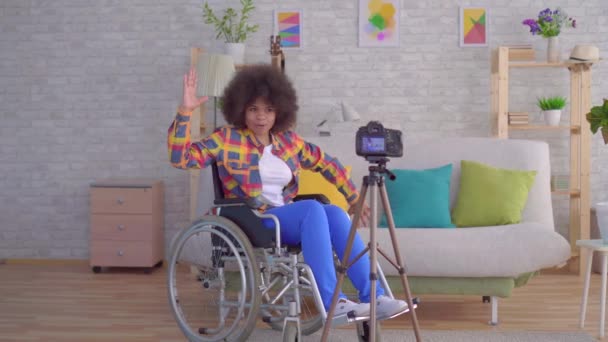 Afrikansk kvinna bloggare funktionshindrade i en rullstol med en afro frisyr innan kameran — Stockvideo