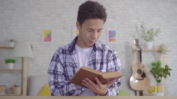Portret jonge Aziatische man lezen boek — Stockvideo
