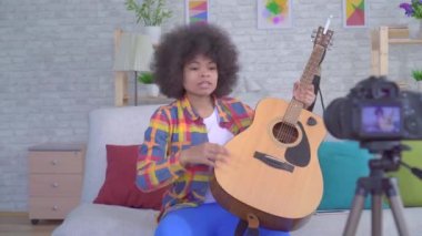 Kamera önce bir gitar ile bir afro saç modeli ile Afrikalı kadın blogger