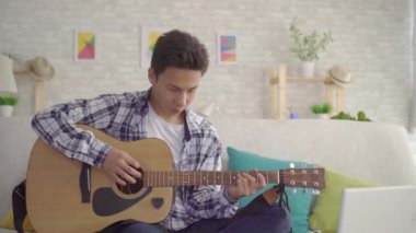 Portre genç asyalı müzisyen gitar çalar