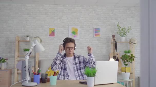 Joven asiático hombre escuchar enérgico música con auriculares y bailando — Vídeo de stock