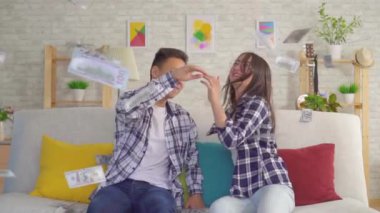 Genç asya çift kanepede kağıt banknotlar yavaş mo yakalamak oturuyor