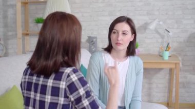 yakın çekim yüz güzel sağır genç kadın evde oturma odasında İşaret Dili ile talking