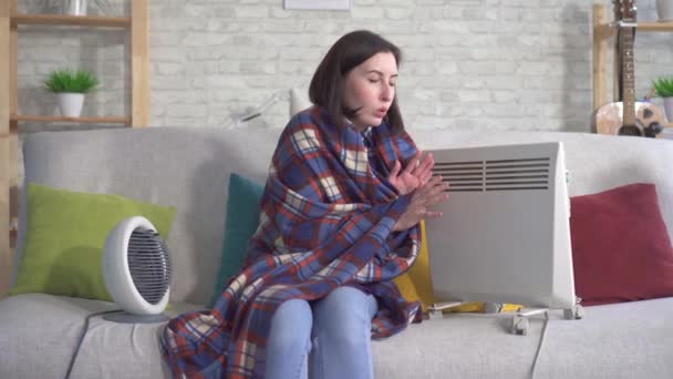 Young woman is freezing in her apartment in the living room — Stock Video