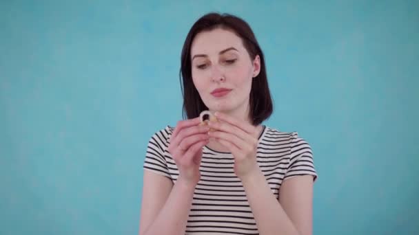 Young woman with hearing impairment hears without hearing aid on blue background — Stock Video