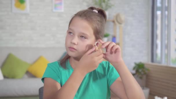 Portrait hard of hearing teen girl with hearing aid in ear — Stock Video
