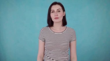 Mavi arka plan üzerinde işitme cihazı ile işitme engelli gülümseyen genç kadın portresi