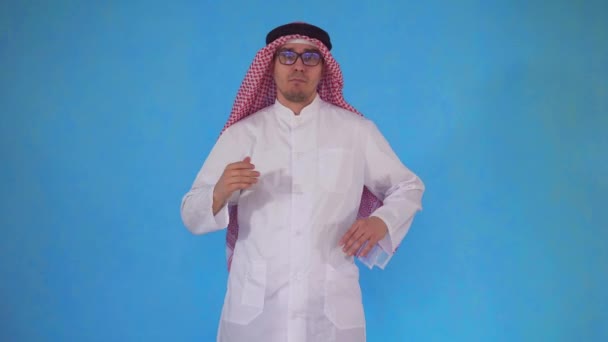 Confuso arabo uomo sta su uno sfondo blu — Video Stock