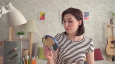 işitme kadın sıkıntılı genç sert kulağına bir işitme cihazı koyar ve aynaya bakar
