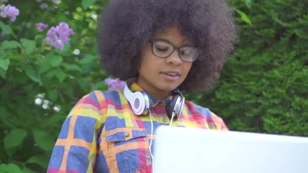 Porträt afrikanisch-amerikanische Frau mit Afro-Frisur benutzt Laptop auf Bank auf der Straße — Stockvideo