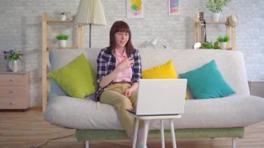 Gözlüklü genç bir kadın Internet üzerinde iletişim kurmak için sağır dilini kullanır
