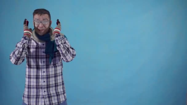 파란색 배경 복사 공간에 장갑과 스카프에 서리로 덮여 긍정적 인 에너지 냉동 남자 — 비디오