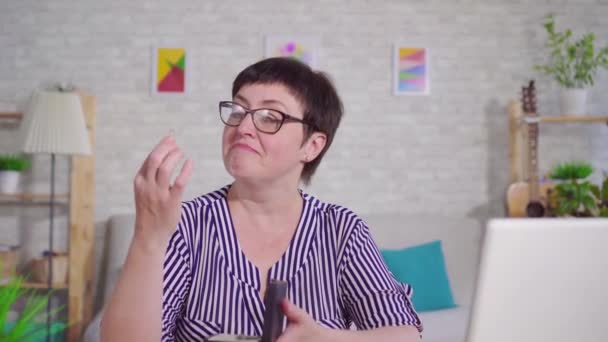 거실에 앉아 보청기 들고 있는 청각 장애인 미소 짓는 여성의 초상화 — 비디오