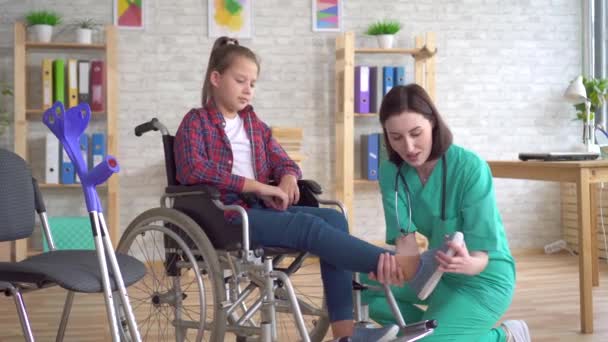 在医生接待下坐在轮椅上受伤的少女 — 图库视频影像